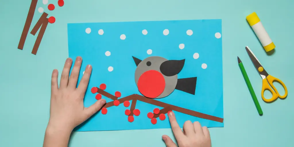 Children's paper bird craft with scissors and glue stick