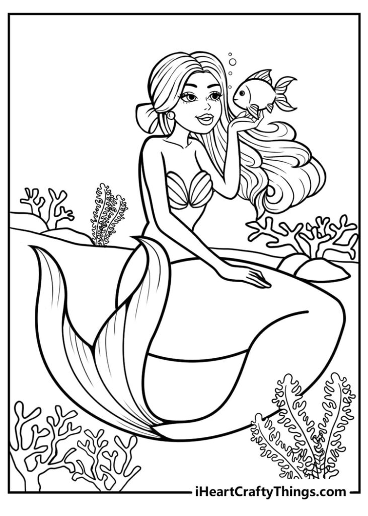 Mermaid holding a fish underwater among coral